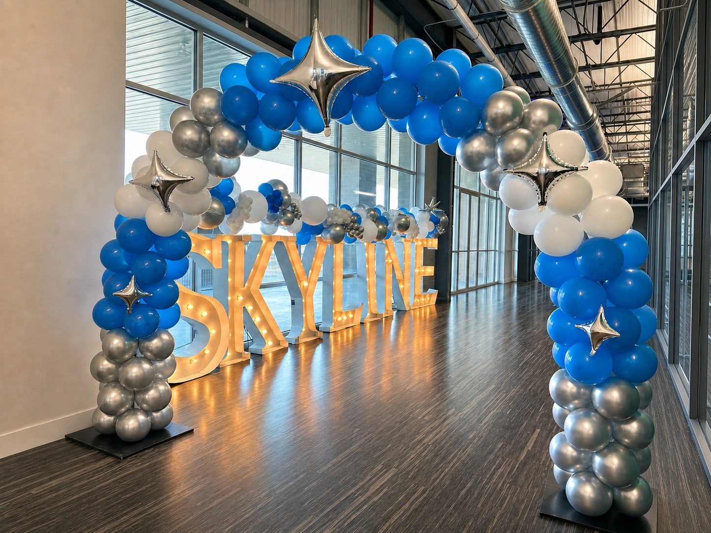 Blue and silver balloon arch at a skyline entrance