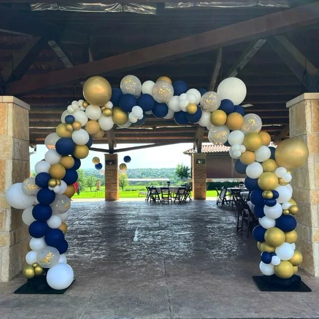 Navy, gold, and white balloon arch under an open pavilion