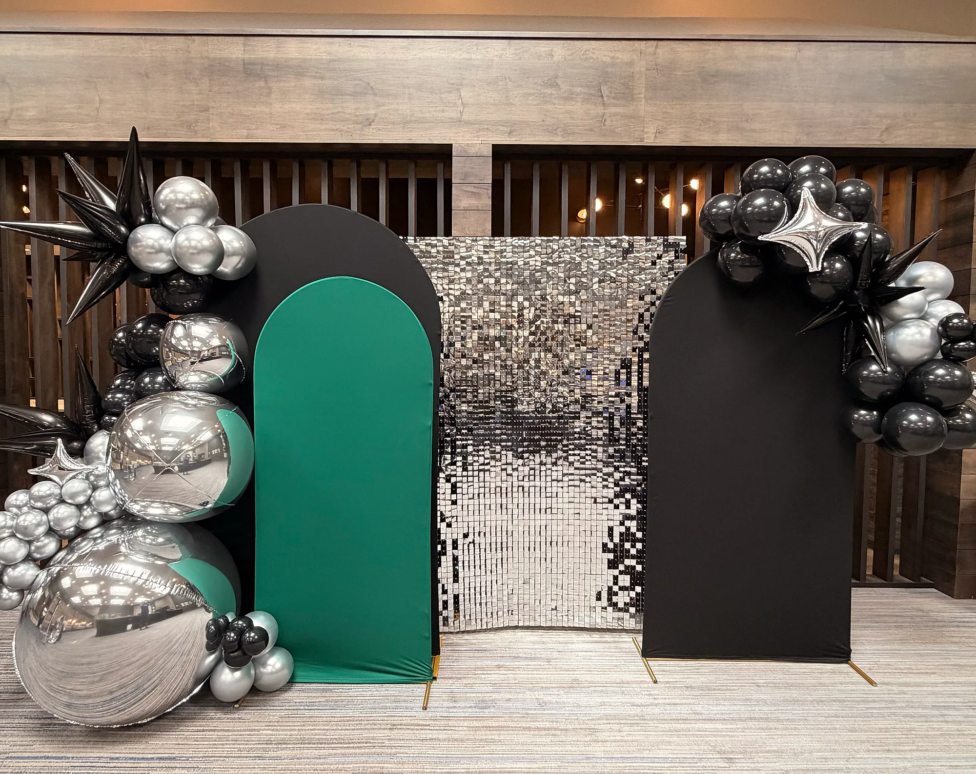 Black and green arched backdrop panels with silver sequins and balloons