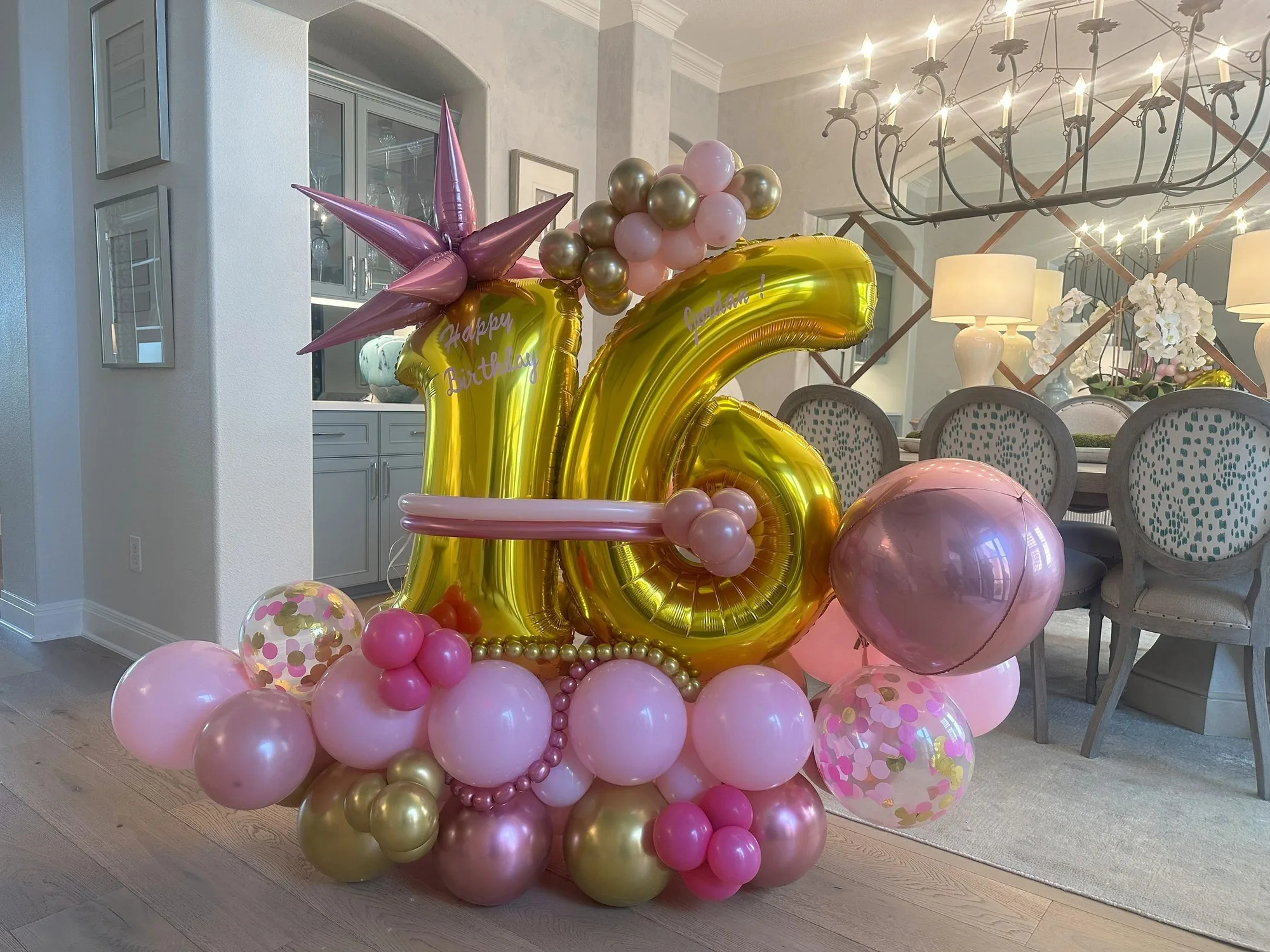 Gold sixteen freestanding balloon display with pink starburst accents