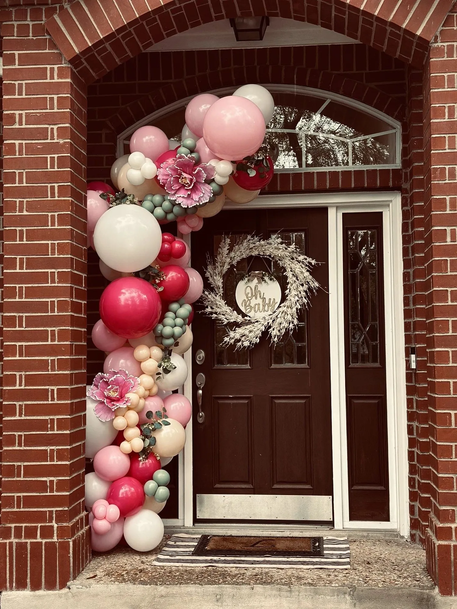 Pink floral balloon garland around a front door